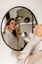 De Face Cupping Specialist voor de spiegel met Face Cups van Pureli Skincare in haar handen. Zij voert de Face Cupping Routine uit.